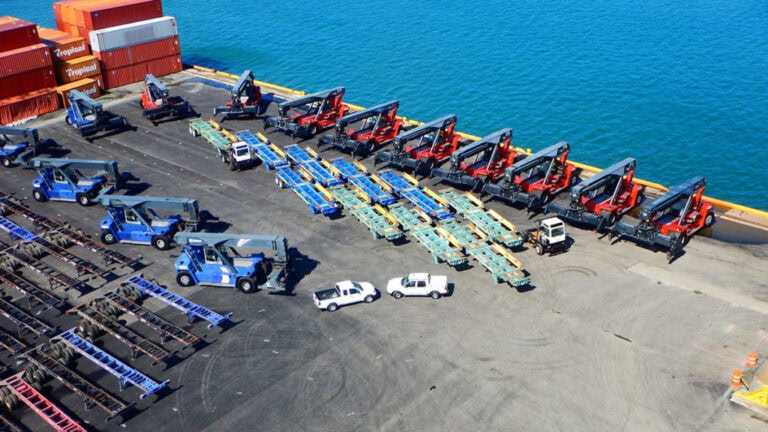 Cargo loading area at Puerto Rico terminal with trucks and containers ready for shipment.